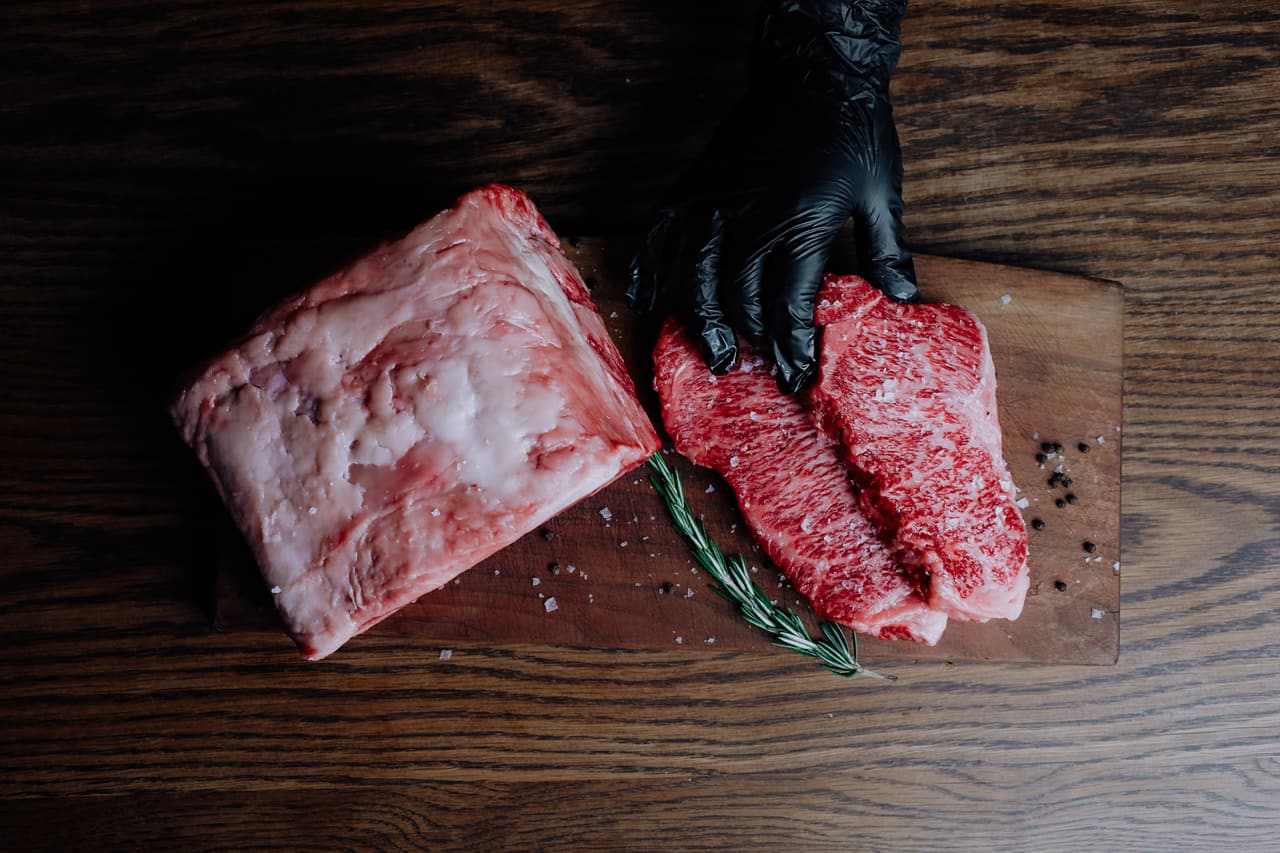 Hand-selected raw steaks on a butcher's board